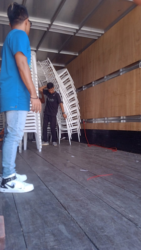 A Citywide employee stacking chairs together in a truck