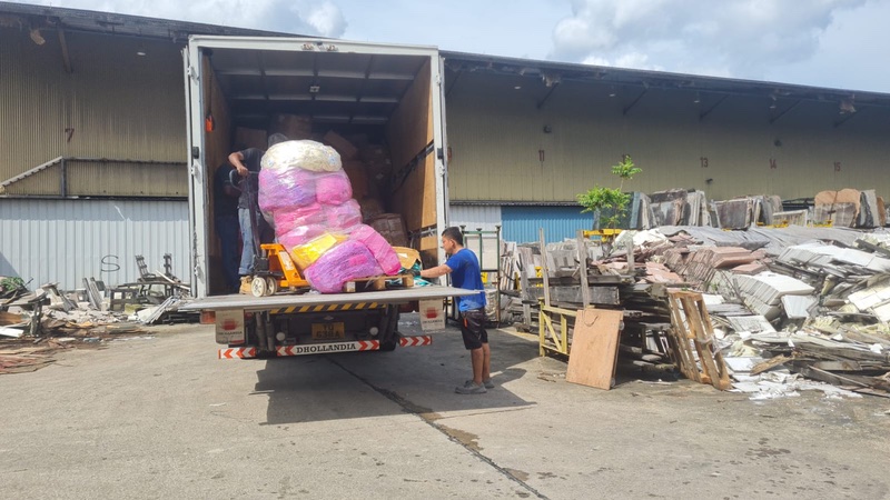 Two persons providing disposal service by unloading materials from a truck for proper disposal